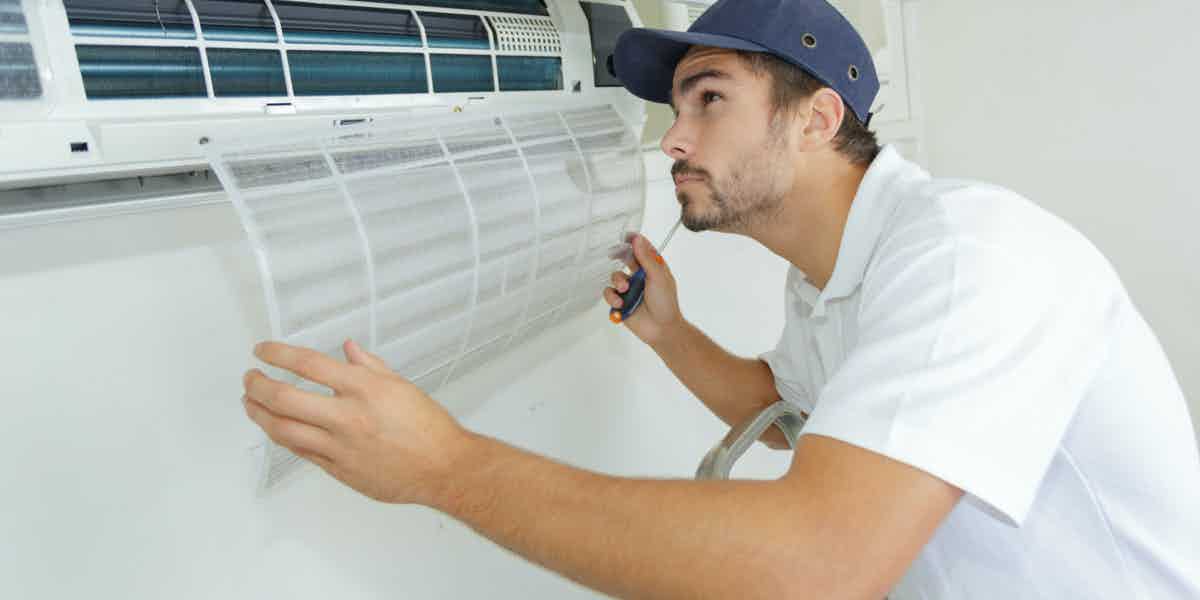 Technician removing an air-conditioner filter during indoor cooling service