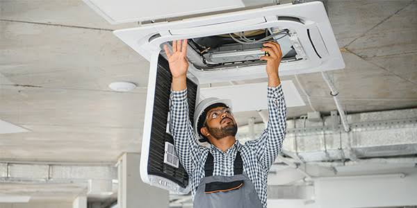 Technician working on a ceiling cassette during HVAC equipment service
