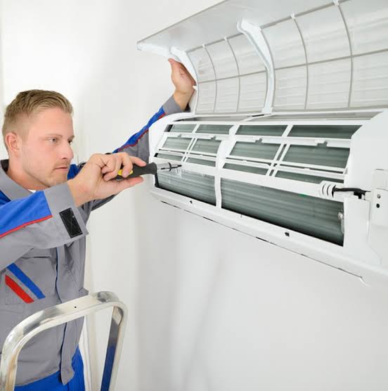Technician opening a ductless mini-split indoor unit for service