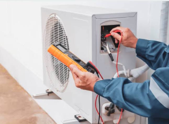Technician testing an outdoor condenser with a multimeter